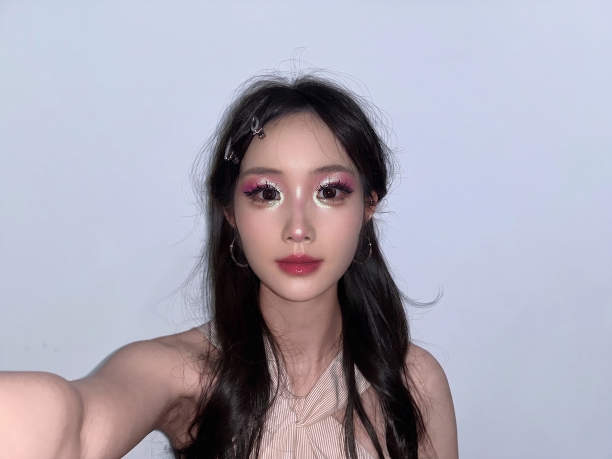 Model wearing OURBELLA multichrome eyeshadow under direct light.