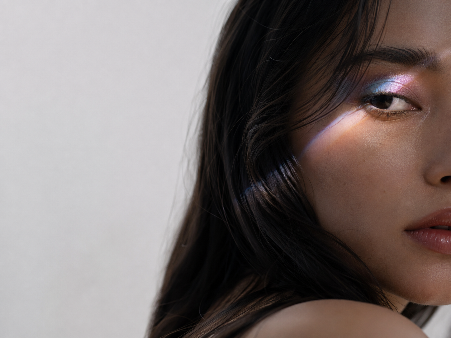 Woman wearing blue-pink multichrome eyeshadow in shifting light