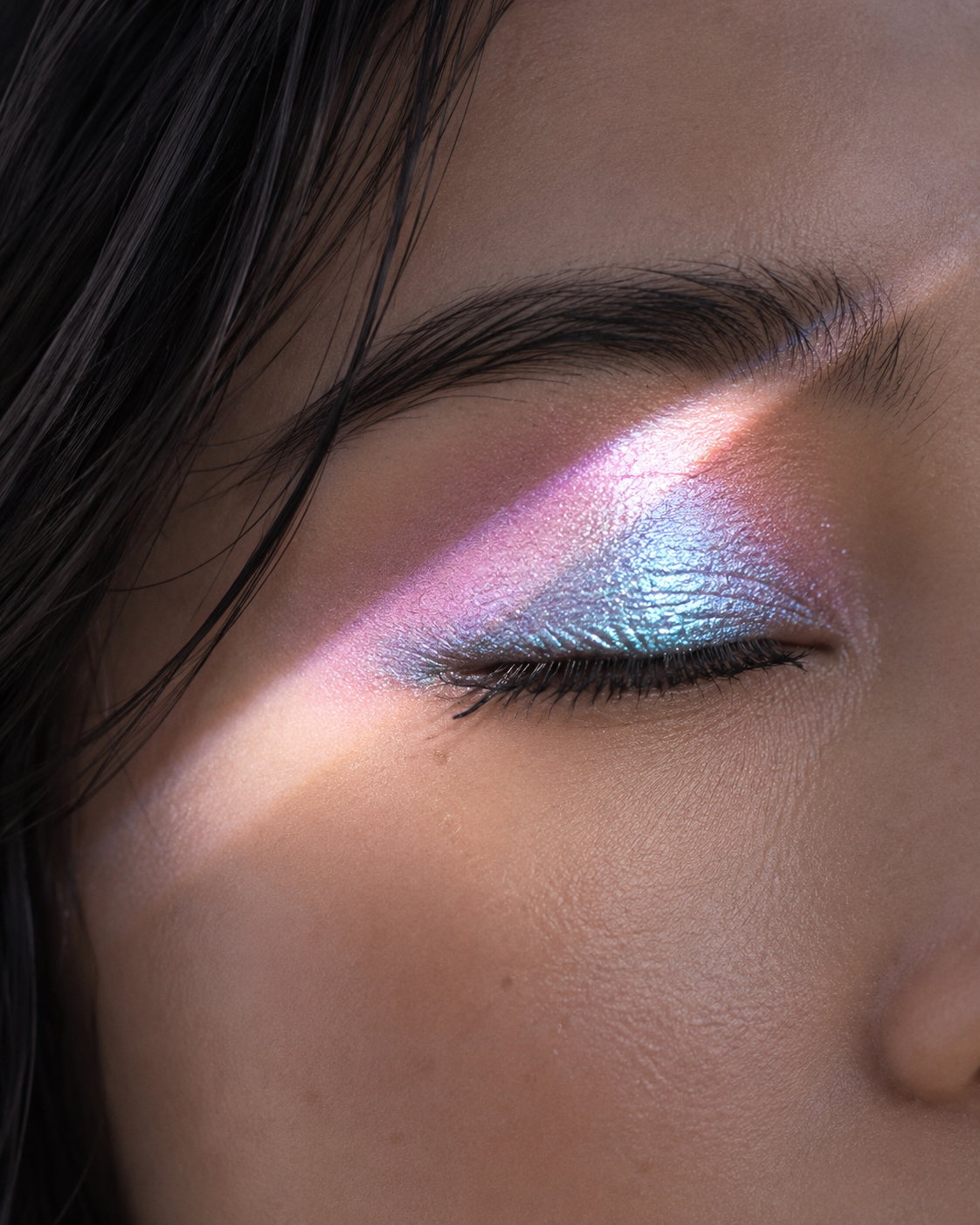 Blue-pink multichrome eyeshadow revealing different tones under angled light
