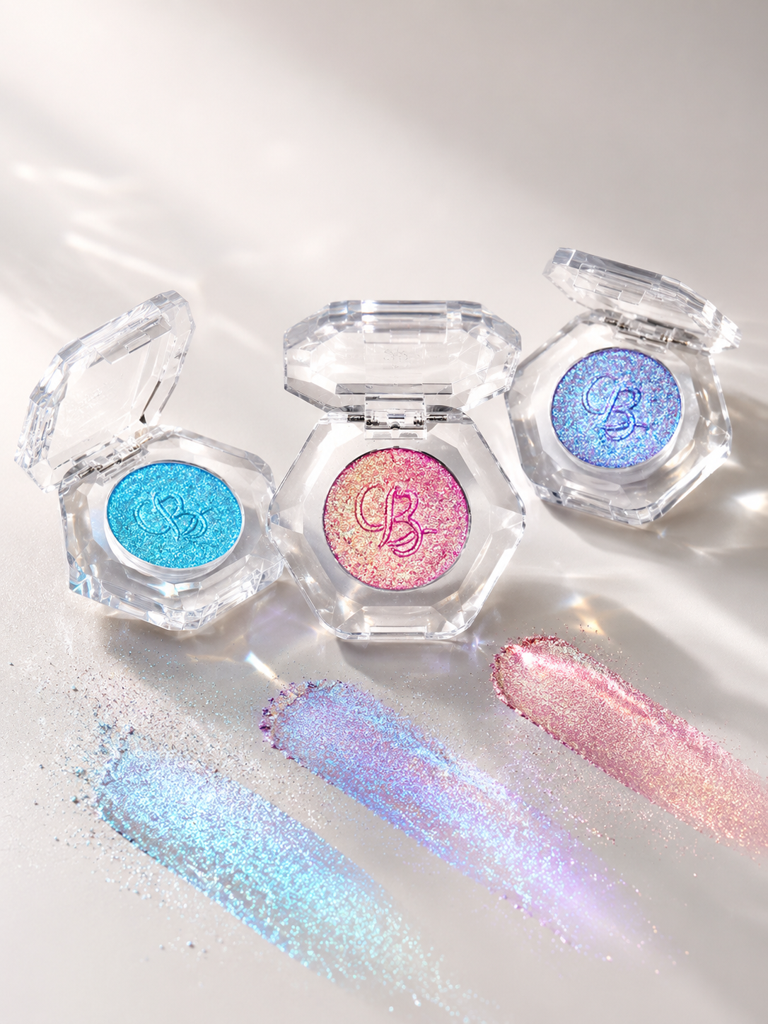 Open OURBELLA multichrome single eyeshadows with blue, pink and lavender swatches.